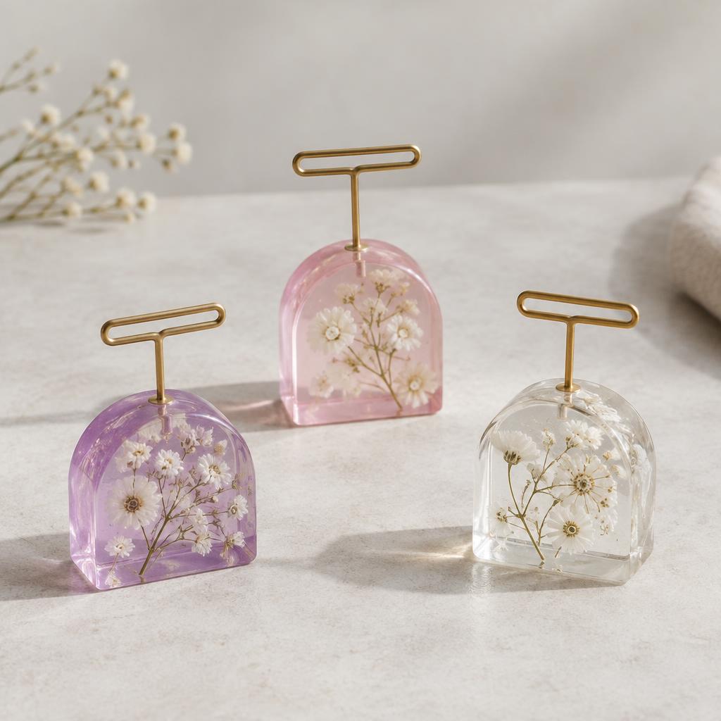 Trois marque-places en résine transparente rose et violette avec fleurs blanches
